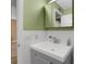 Bright bathroom with a green accent wall and a modern vanity with storage at 2256 Philippine Dr # 24, Clearwater, FL 33763