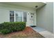 Street view of the front door with mulched garden bed and lush hedges underneath the front windows at 2256 Philippine Dr # 24, Clearwater, FL 33763