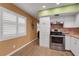 Modern kitchen with stainless steel appliances, white cabinetry, and warm earth tone walls at 2256 Philippine Dr # 24, Clearwater, FL 33763