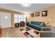 Living area features a blue sofa, comfortable armchairs, shuttered windows, and wood-look flooring at 2256 Philippine Dr # 24, Clearwater, FL 33763