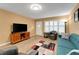 View of the well-lit living area that includes a sofa, mounted TV, and wood-look flooring at 2256 Philippine Dr # 24, Clearwater, FL 33763