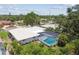 An aerial view reveals a home with a screened pool, surrounded by lush greenery in a tranquil neighborhood at 2418 Cardwell Way, Sarasota, FL 34231