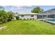 A well-maintained lawn stretches from the house to a screened-in pool enclosure at 2418 Cardwell Way, Sarasota, FL 34231