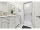 Updated bathroom with double sink vanity with white cabinets, marble countertop, modern fixtures, and ample lighting at 2418 Cardwell Way, Sarasota, FL 34231