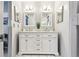 Updated bathroom with double sink vanity with white cabinets, marble countertop, modern fixtures, and ample lighting at 2418 Cardwell Way, Sarasota, FL 34231