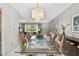 Elegant dining room with modern chandelier, glass table, and seamless transition to living area at 2418 Cardwell Way, Sarasota, FL 34231