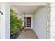 Inviting entryway featuring a covered porch with textured walls, stone accents, and a charming front door at 2418 Cardwell Way, Sarasota, FL 34231