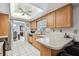 Spacious kitchen offering white tile floors, wood cabinetry, and an eat-in breakfast bar at 2418 Cardwell Way, Sarasota, FL 34231