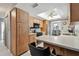 Well-lit kitchen boasts wood cabinets, breakfast bar, and appliances, flowing to the dining area at 2418 Cardwell Way, Sarasota, FL 34231