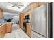 Functional kitchen with wood cabinetry, white tile flooring, and modern appliances, perfect for culinary adventures at 2418 Cardwell Way, Sarasota, FL 34231