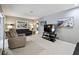 Comfortable living room featuring neutral walls, plush carpeting, and modern entertainment center with large television at 2418 Cardwell Way, Sarasota, FL 34231