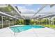 A crystal-clear pool is enclosed in a screened lanai overlooking the backyard at 2418 Cardwell Way, Sarasota, FL 34231