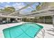 A sparkling pool and outdoor seating are enclosed by a screened-in lanai at 2418 Cardwell Way, Sarasota, FL 34231