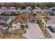 An aerial view of a beautiful home with a paved driveway and a cozy front porch in a quiet neighborhood at 2457 E Del Webb Blvd, Sun City Center, FL 33573
