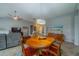 Open-concept dining area with a wooden table, chandelier, and view of the living room, perfect for Gathering gatherings at 2457 E Del Webb Blvd, Sun City Center, FL 33573