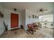 Cozy front porch features tiled flooring, rocking chairs, and a vibrant orange front door for a welcoming entrance at 2457 E Del Webb Blvd, Sun City Center, FL 33573
