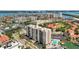 Aerial view of the high rise building, lush landscaping, and marina at 255 Dolphin Pt # 207, Clearwater Beach, FL 33767