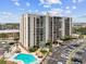 Stunning aerial view of condo complex with a pool, parking, and lush landscaping, showcasing its prime location and amenities at 255 Dolphin Pt # 207, Clearwater Beach, FL 33767