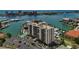 Aerial view of condo building near a waterfront area, featuring boating docks, and a swimming pool at 255 Dolphin Pt # 207, Clearwater Beach, FL 33767