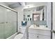 Well-lit bathroom featuring a shower with glass doors, modern fixtures, and mosaic tile accents at 255 Dolphin Pt # 207, Clearwater Beach, FL 33767