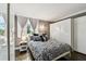 Cozy bedroom with a patterned bedspread, ample natural light, and large closet space at 255 Dolphin Pt # 207, Clearwater Beach, FL 33767