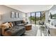 Living room showcasing a large picture window with outside views, a plush couch and grey walls at 255 Dolphin Pt # 207, Clearwater Beach, FL 33767