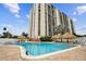 Beautiful condominium complex pool with shade palapas and lounge chairs for relaxing on a summer afternoon at 255 Dolphin Pt # 207, Clearwater Beach, FL 33767