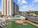 Exterior shot of a waterfront condo building with a pool, tiki umbrellas, and parking at 255 Dolphin Pt # 207, Clearwater Beach, FL 33767