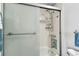 Modern shower with glass sliding doors, tiled walls, and shower accessories at 255 Dolphin Pt # 207, Clearwater Beach, FL 33767