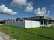 Fenced backyard with green grass beneath blue skies offers privacy and space for outdoor activities at 2619 Albion St, Holiday, FL 34691