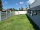 Fenced backyard with green grass beneath blue skies offers privacy and space for outdoor activities at 2619 Albion St, Holiday, FL 34691