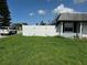 Fenced backyard with green grass beneath blue skies offers privacy and space for outdoor activities at 2619 Albion St, Holiday, FL 34691