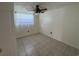 This bedroom features a ceiling fan, tile floors, and a large window at 2619 Albion St, Holiday, FL 34691
