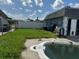 A kidney-shaped pool is the focal point of this backyard with green grass at 2619 Albion St, Holiday, FL 34691