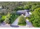 Stunning brick home with lush landscaping, a circular driveway, and a screened pool area at 302 Eastleigh Dr, Belleair, FL 33756