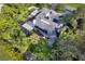 Beautiful home featuring a solar panel roof, manicured backyard, and lush tropical landscaping at 302 Eastleigh Dr, Belleair, FL 33756