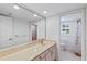 Bright bathroom featuring a large mirror over a vanity, toilet, shower and window with white shutters at 302 Eastleigh Dr, Belleair, FL 33756