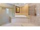 Corner bathtub with jacuzzi jets next to glass shower and chrome towel heater at 302 Eastleigh Dr, Belleair, FL 33756