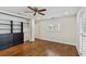 Bedroom featuring hardwood floors, ceiling fan and built in closet with door to the hallway at 302 Eastleigh Dr, Belleair, FL 33756