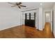 Bedroom with hardwood floors, ceiling fan and built in closet with view to the hallway at 302 Eastleigh Dr, Belleair, FL 33756