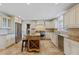 Bright kitchen featuring stone countertops, stainless steel appliances, an island and tile flooring at 302 Eastleigh Dr, Belleair, FL 33756