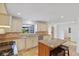 Bright kitchen with stone countertops, travertine floors, a custom island and stainless steel appliances at 302 Eastleigh Dr, Belleair, FL 33756