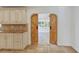 Rustic sliding barn doors off kitchen to light filled living room with travertine floors at 302 Eastleigh Dr, Belleair, FL 33756