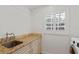 Bright laundry room with countertop, cabinets, sink, and window at 302 Eastleigh Dr, Belleair, FL 33756