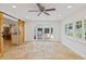 Open floor plan living room with travertine floors, barn doors, and French door to the outside at 302 Eastleigh Dr, Belleair, FL 33756
