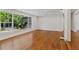 Spacious living room with wood floors, large windows showcasing tropical foliage, and recessed lights at 302 Eastleigh Dr, Belleair, FL 33756