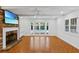 Bright living room featuring exposed brick fireplace and French doors leading to a pool area at 302 Eastleigh Dr, Belleair, FL 33756