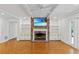 Spacious living room with exposed brick fireplace, white built-in shelving, and parquet wood flooring at 302 Eastleigh Dr, Belleair, FL 33756