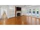 Bright living room featuring exposed brick fireplace and French doors leading to a pool area at 302 Eastleigh Dr, Belleair, FL 33756