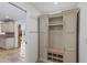 Mudroom featuring custom built-in storage lockers, travertine floors, and access to kitchen and living room at 302 Eastleigh Dr, Belleair, FL 33756